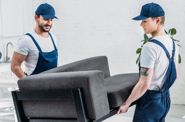 Moving helper carrying a sofa